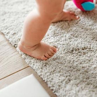 A professionally cleaned rug with a baby playing on it in Townsville